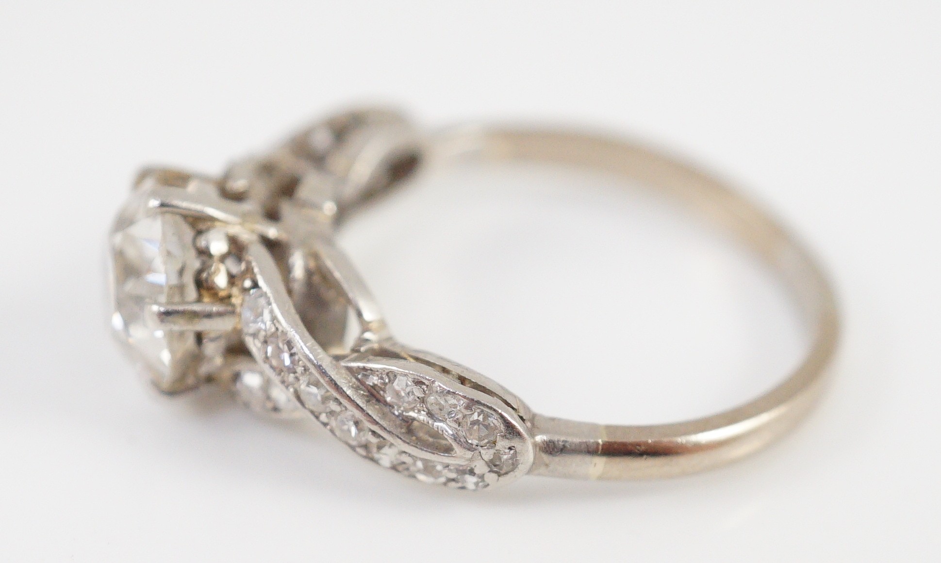 A mid 20th century white gold and single stone diamond ring, with diamond set crossover shoulders